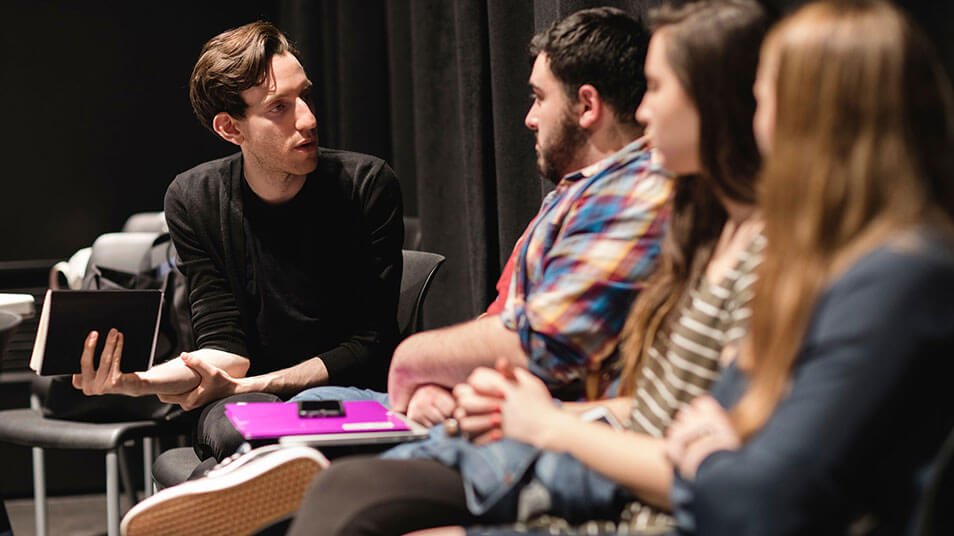 Students talk to one another and get feedback after acting out a theater scene